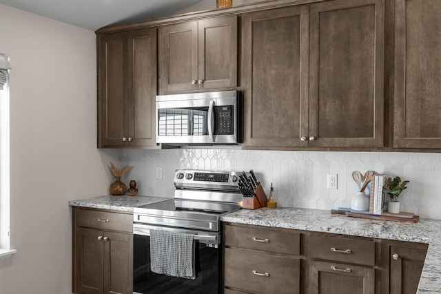 5928 Th St W, Lakeville, MN 55044 - kitchen with appliances with stainless steel finishes, decorative backsplash, dark brown cabinets, and light stone countertops