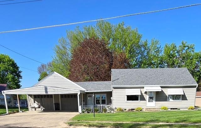view of front of home with concrete driveway, a front lawn, and a garage
