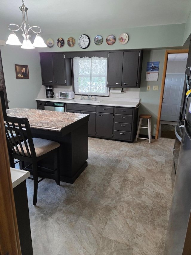 218 Lake Ave E, Fulda, MN 56131 - kitchen with stainless steel dishwasher, a sink, light countertops, a chandelier, and decorative light fixtures