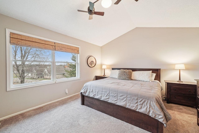 bedroom with vaulted ceiling, carpet floors, baseboards, and ceiling fan