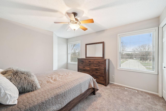 bedroom featuring ceiling fan, baseboards, and light carpet
