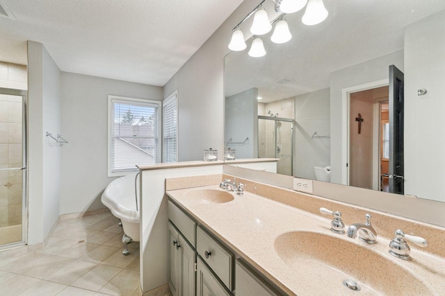 bathroom with visible vents, tile patterned flooring, a stall shower, and a sink