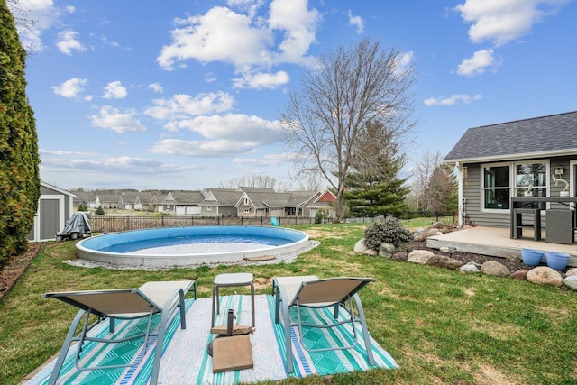 view of pool with a storage shed, fence, an outbuilding, a yard, and a fenced in pool
