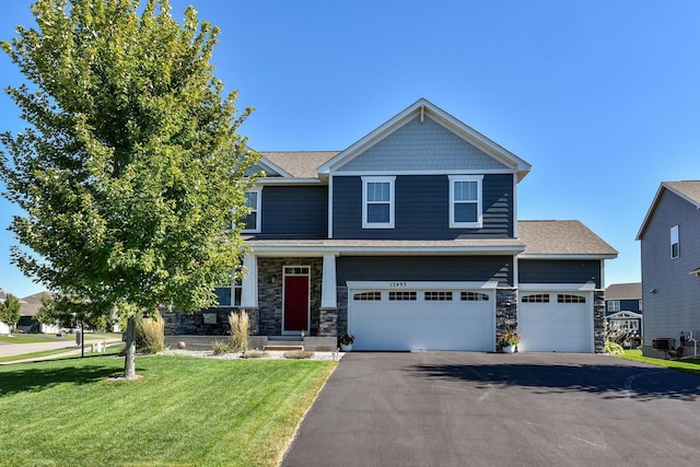 craftsman inspired home with a front lawn, stone siding, a garage, a shingled roof, and aphalt driveway