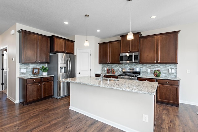kitchen featuring dark wood finished floors, appliances with stainless steel finishes, decorative backsplash, and a sink