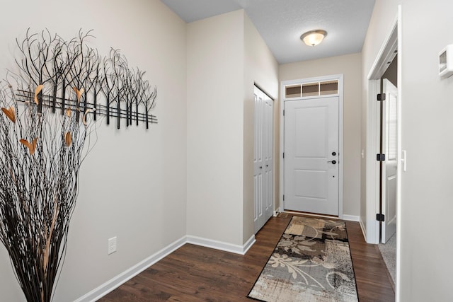 doorway to outside with dark wood finished floors and baseboards