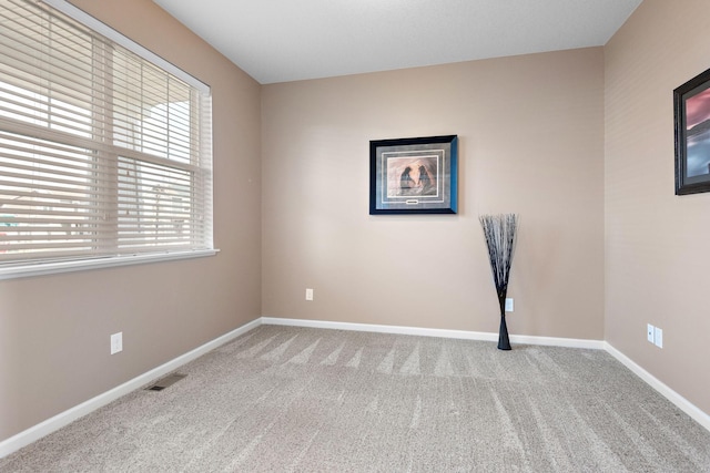carpeted empty room with baseboards and visible vents