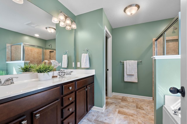 full bath with visible vents, a sink, a shower stall, and double vanity