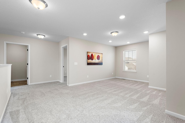 below grade area with recessed lighting, baseboards, and light carpet