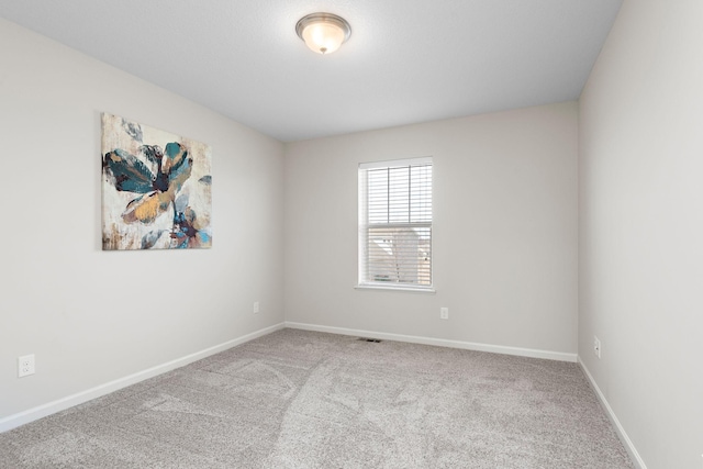 unfurnished room featuring visible vents, baseboards, and carpet