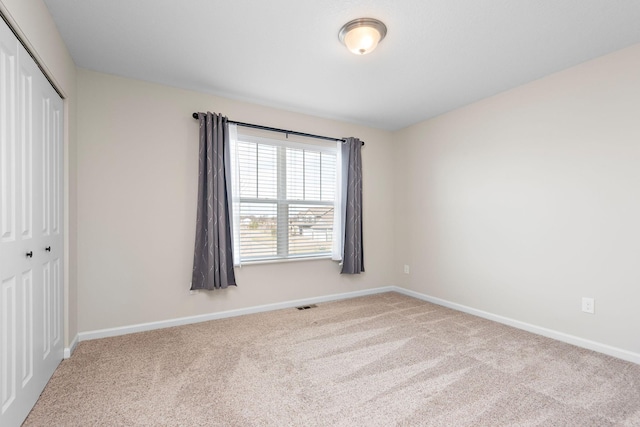 unfurnished bedroom with carpet floors, a closet, and baseboards
