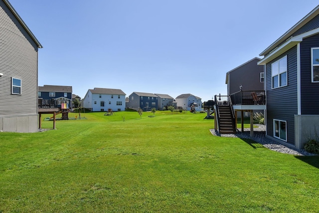 view of yard featuring a wooden deck, a residential view, and stairs