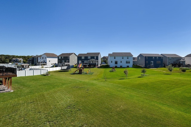 view of yard with fence, playground community, and a residential view