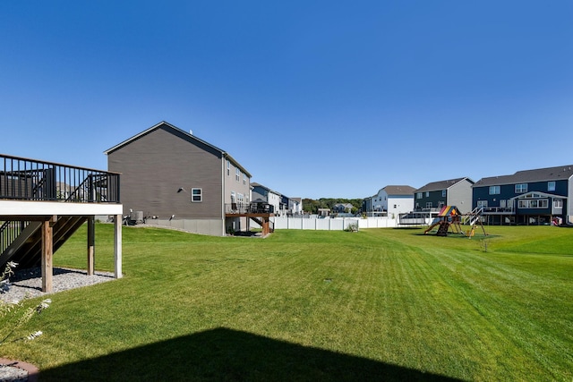 view of yard with stairway, fence, a residential view, and a playground
