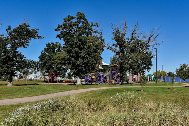 view of property's community featuring playground community and a yard