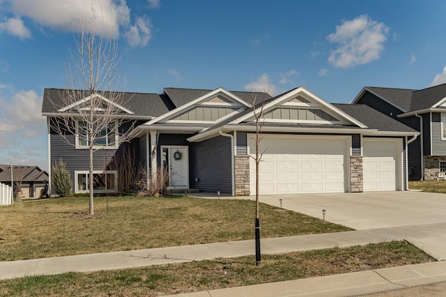 view of front of home featuring board and batten siding, driveway, stone siding, a front yard, and a garage