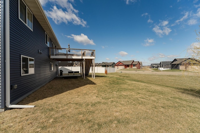 view of yard with a wooden deck, stairs, and a residential view