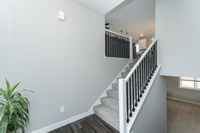 stairway with wood finished floors and baseboards