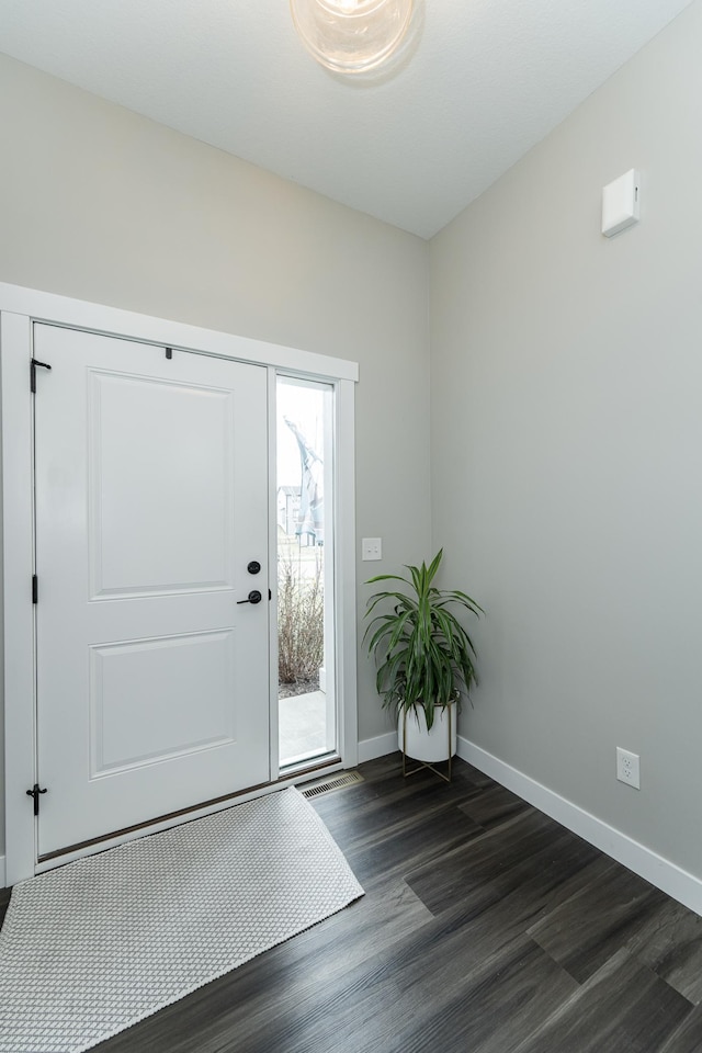 entryway featuring baseboards and dark wood finished floors