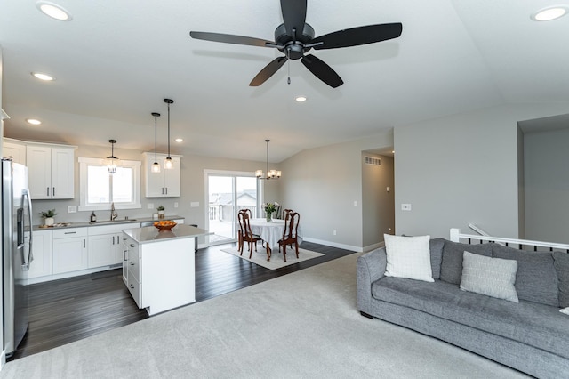kitchen featuring dark colored carpet, a sink, stainless steel fridge, recessed lighting, and a kitchen island