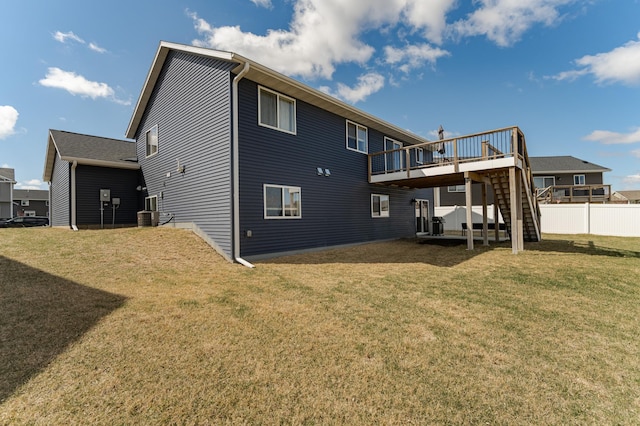 rear view of property featuring a yard, stairway, fence, and a deck