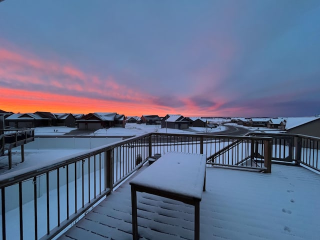 snow covered deck featuring a residential view