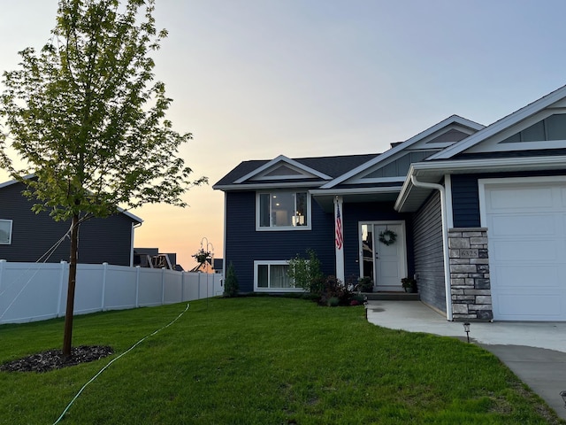 view of front of home with fence, an attached garage, board and batten siding, stone siding, and a front yard