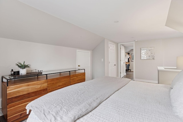 bedroom with baseboards and vaulted ceiling