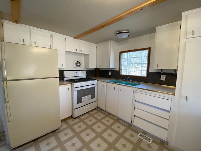 W8108 Vernon Ave, Chicog Twp, WI 54888 - kitchen with a sink, white appliances, light floors, white cabinetry, and visible vents