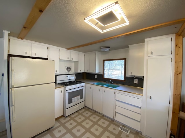 W8108 Vernon Ave, Chicog Twp, WI 54888 - kitchen with a sink, white appliances, light floors, white cabinets, and visible vents