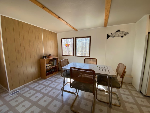 W8108 Vernon Ave, Chicog Twp, WI 54888 - dining area featuring light floors, wooden walls, beamed ceiling, and visible vents