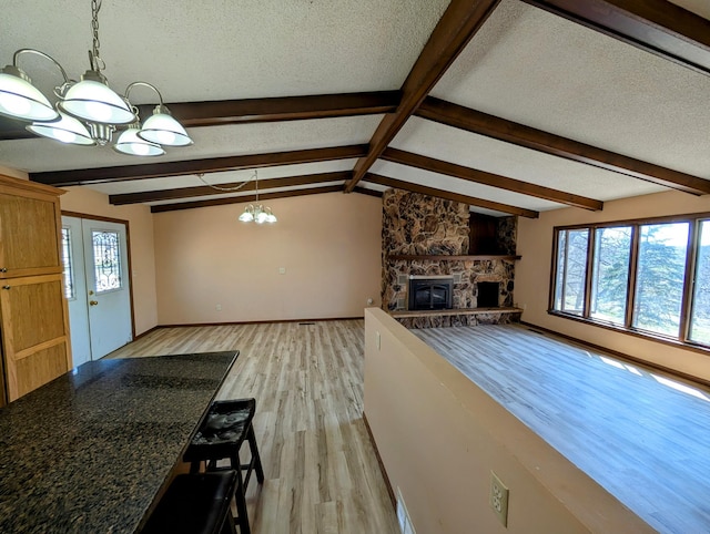 1433 Ridgeview Dr, Montevideo, MN 56265 - unfurnished living room with a chandelier, light wood finished floors, a fireplace, a textured ceiling, and baseboards