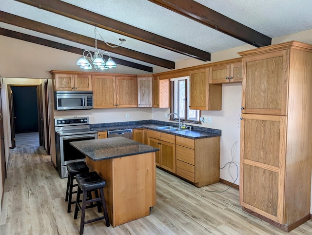 1433 Ridgeview Dr, Montevideo, MN 56265 - kitchen featuring appliances with stainless steel finishes, a sink, light wood-type flooring, a center island, and a textured ceiling