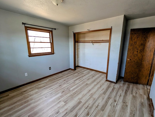 1433 Ridgeview Dr, Montevideo, MN 56265 - unfurnished bedroom featuring light wood finished floors, a textured ceiling, a closet, and baseboards