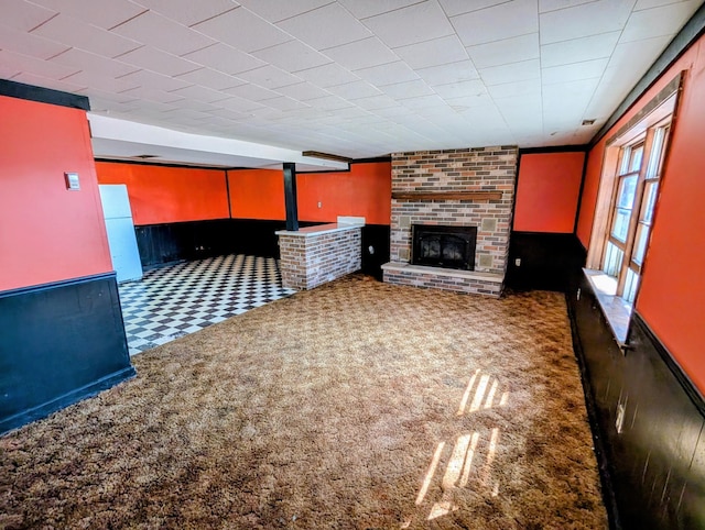 1433 Ridgeview Dr, Montevideo, MN 56265 - unfurnished living room with carpet floors, a fireplace, a wainscoted wall, and wood walls