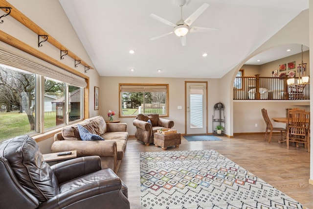 living area with arched walkways, vaulted ceiling, and plenty of natural light