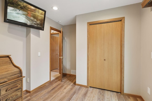 unfurnished bedroom featuring a closet, light wood-style floors, baseboards, visible vents, and recessed lighting