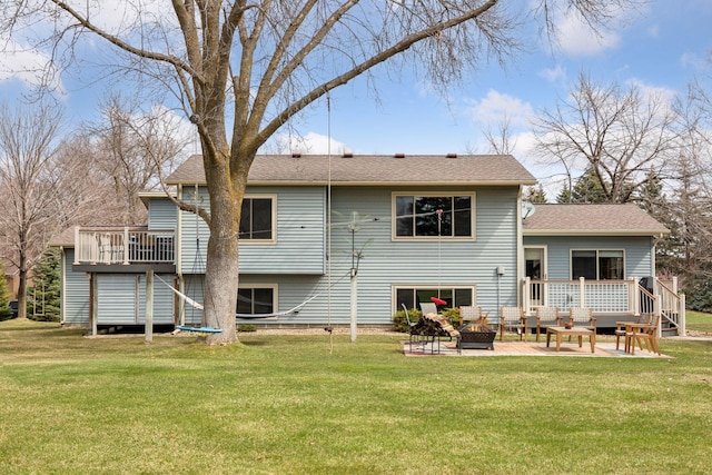 rear view of property featuring a lawn, an outdoor living space with a fire pit, and a deck
