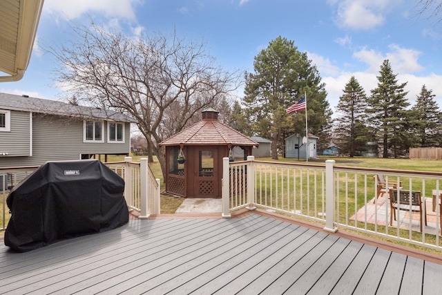wooden terrace with a gazebo, a yard, and area for grilling