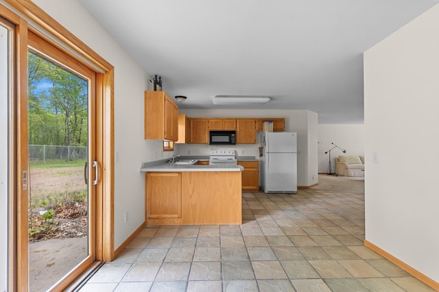 7051 Fox Rd, Baxter, MN 56425 - kitchen with white appliances, a sink, baseboards, a peninsula, and light countertops
