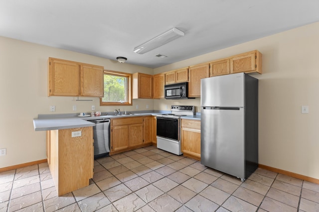 7051 Fox Rd, Baxter, MN 56425 - kitchen with stainless steel appliances, baseboards, light countertops, and a peninsula