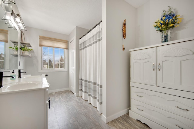 full bath with double vanity, baseboards, and curtained shower