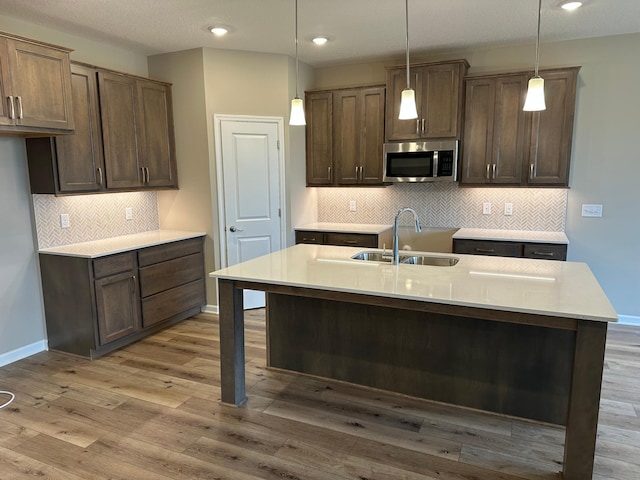 2063 Oakpointe Dr, Waconia, MN 55387 - kitchen with stainless steel microwave, decorative light fixtures, wood finished floors, and recessed lighting