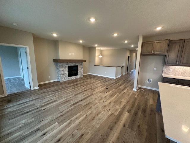2063 Oakpointe Dr, Waconia, MN 55387 - unfurnished living room featuring dark wood-style flooring, recessed lighting, and a fireplace