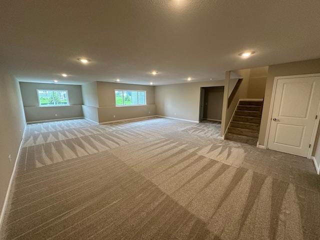 2063 Oakpointe Dr, Waconia, MN 55387 - below grade area with light colored carpet, stairway, and recessed lighting