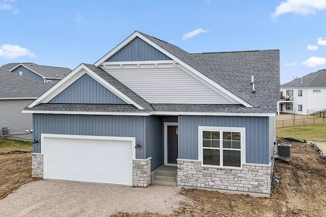 1274 Orchard Ct, Waconia, MN 55387 - view of front of house featuring a shingled roof, stone siding, a garage, and driveway