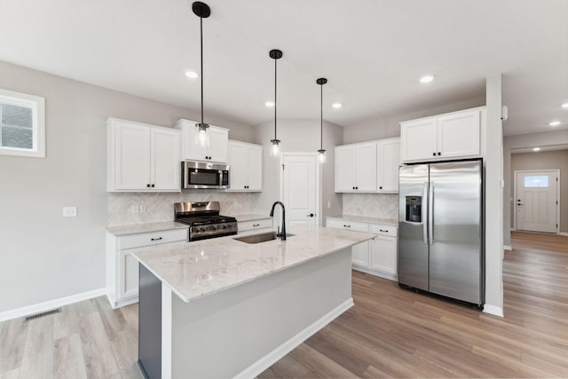 1274 Orchard Ct, Waconia, MN 55387 - kitchen with appliances with stainless steel finishes, light wood-type flooring, decorative backsplash, white cabinets, and decorative light fixtures