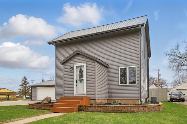 235 3rd St NE, Blooming Prairie, MN 55917 - modern home with central AC unit, a garage, metal roof, entry steps, and a front yard