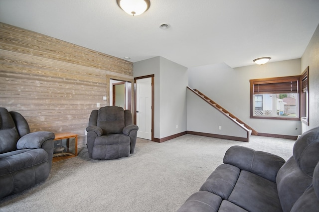 235 3rd St NE, Blooming Prairie, MN 55917 - living room with wooden walls, stairs, carpet flooring, and baseboards