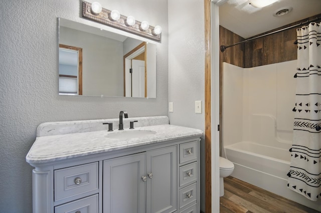 235 3rd St NE, Blooming Prairie, MN 55917 - bathroom with shower / tub combo with curtain, a textured wall, vanity, and wood finished floors